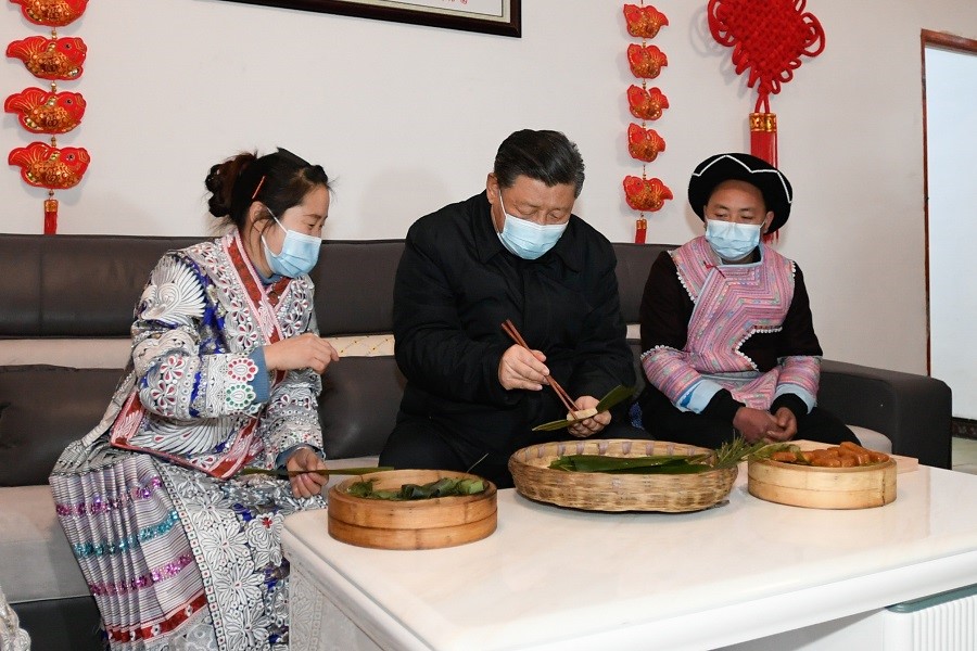2021年2月3日下午，習(xí)近平在貴州畢節(jié)市黔西縣新仁苗族鄉(xiāng)化屋村苗族村民趙玉學(xué)家，同一家人邊聊家常邊制作當(dāng)?shù)貍鹘y(tǒng)節(jié)日食品黃粑。新華社記者 李學(xué)仁 攝