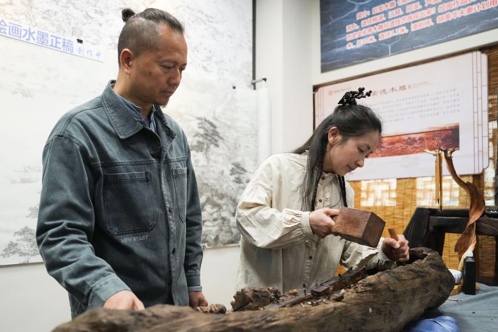 潘能輝和妻子胡美華在湖南常德河街展示木雕。新華社記者 薛宇舸 攝